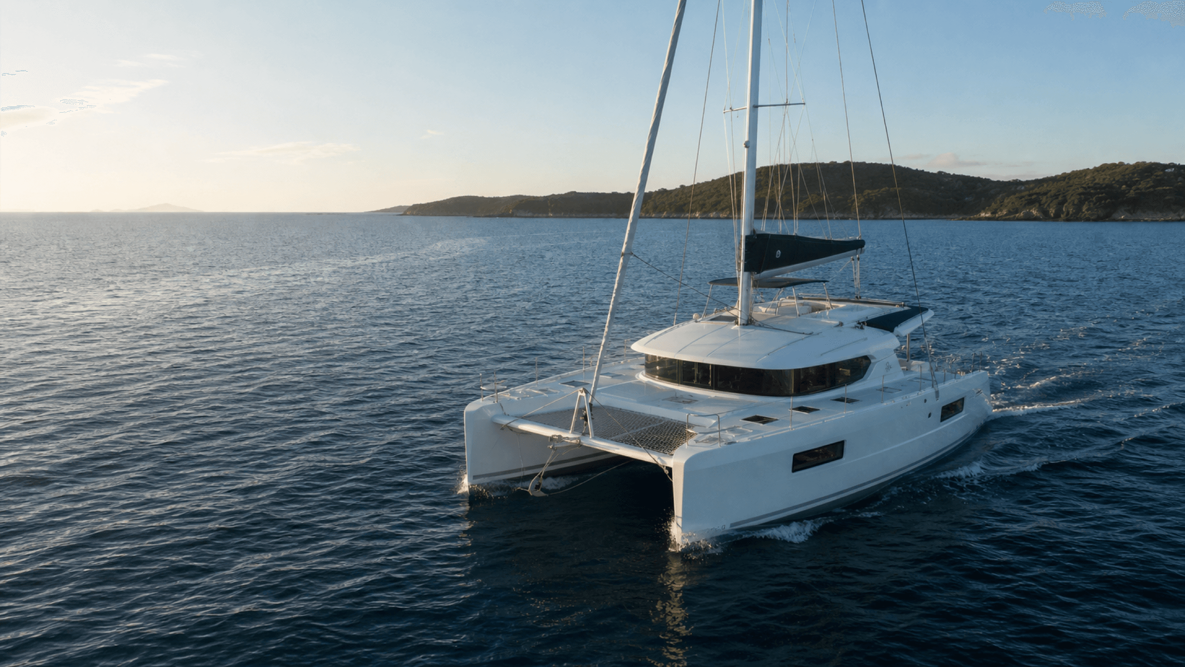 Cruising catamaran underway at sunset